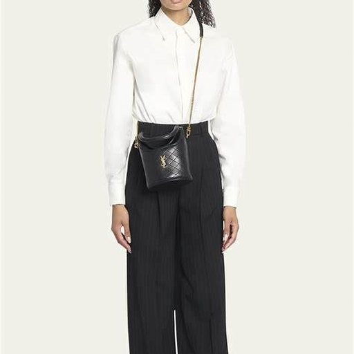 Saint Laurent Gaby Bucket styled with a white shirt and dark tailored trousers